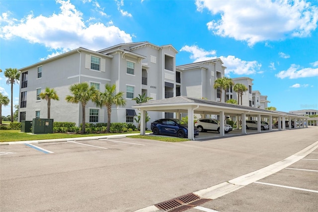 view of property with covered and uncovered parking