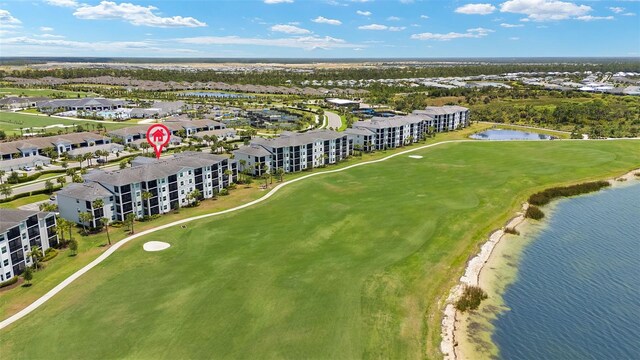 bird's eye view of a golf club, a large body of water, and apartment complex / building