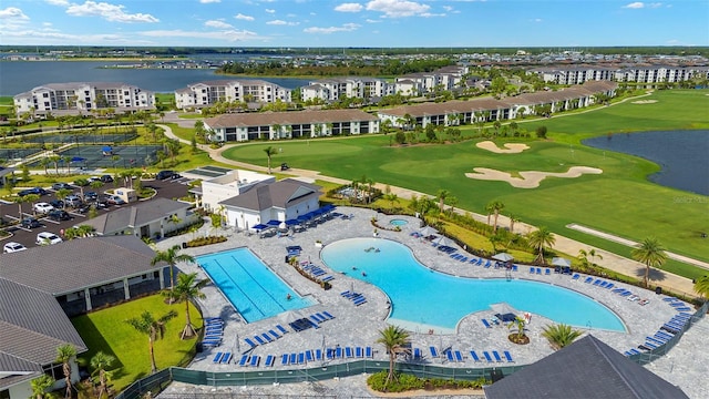 bird's eye view of a nearby body of water, a pool area, and a golf course