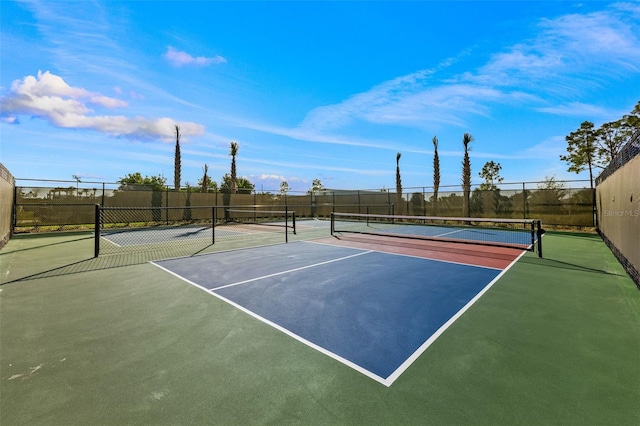 view of tennis court featuring community basketball court and fence