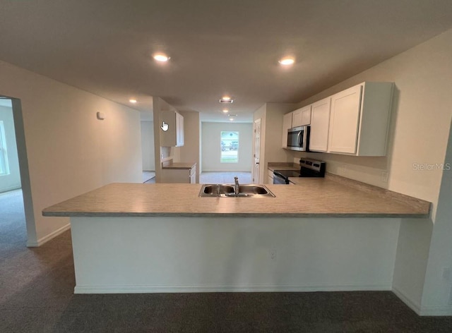 76 Raleigh Dr, Palm Coast, FL 32164 - kitchen with appliances with stainless steel finishes, a sink, a peninsula, dark colored carpet, and white cabinets