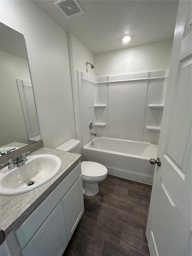 6 Whittier Ln, Palm Coast, FL 32164 - bathroom featuring vanity, toilet, wood finished floors, bathing tub / shower combination, and a textured ceiling