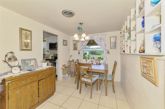 12018 Saragossa Ln, North Port, FL 34287 - dining room featuring a chandelier, light tile patterned floors, and baseboards