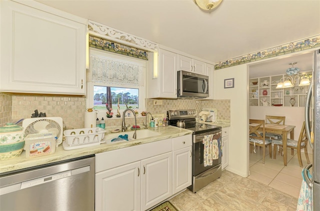 12018 Saragossa Ln, North Port, FL 34287 - kitchen with stainless steel appliances, a sink, decorative backsplash, white cabinets, and light tile patterned flooring