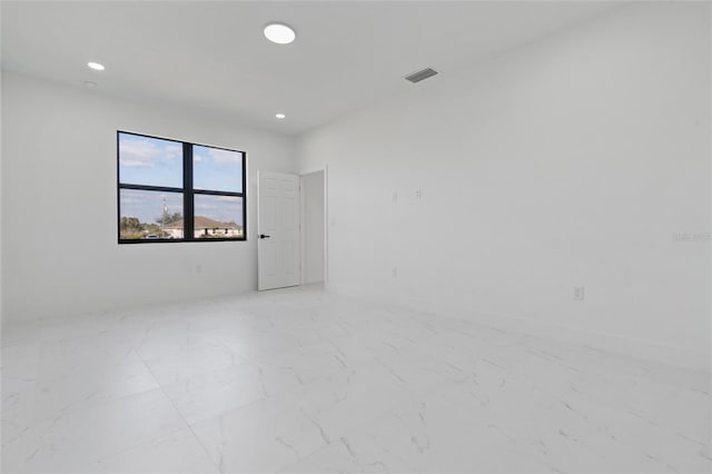 unfurnished room featuring light marble finish flooring and recessed lighting