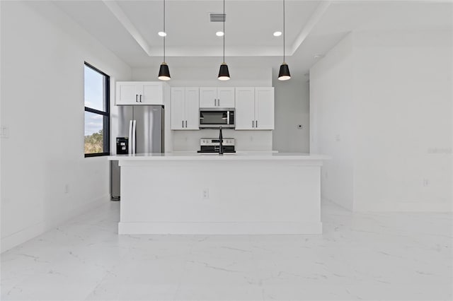 kitchen with stainless steel appliances, white cabinets, a tray ceiling, light marble finish flooring, and recessed lighting
