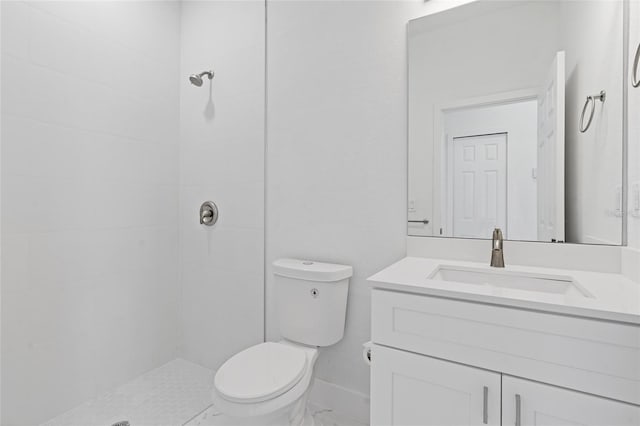 full bath featuring tiled shower, toilet, vanity, and baseboards