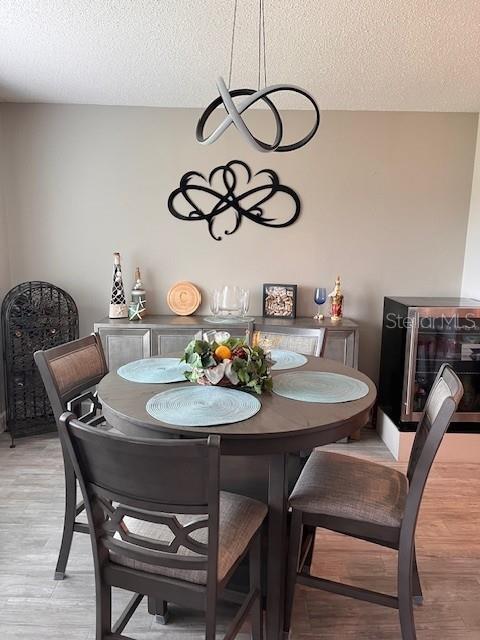 dining room with a textured ceiling and light wood-type flooring