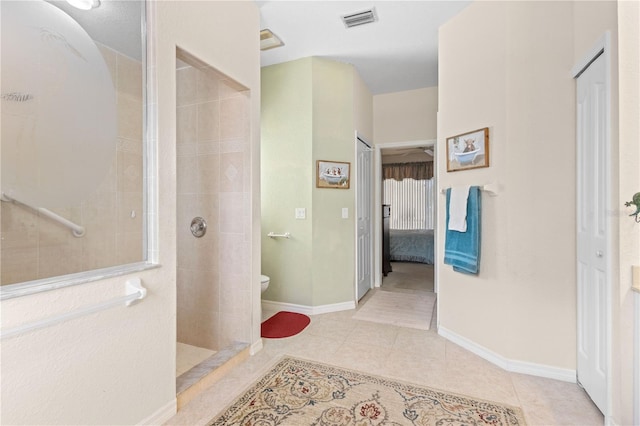 full bathroom with walk in shower, tile patterned floors, baseboards, toilet, and ensuite bathroom