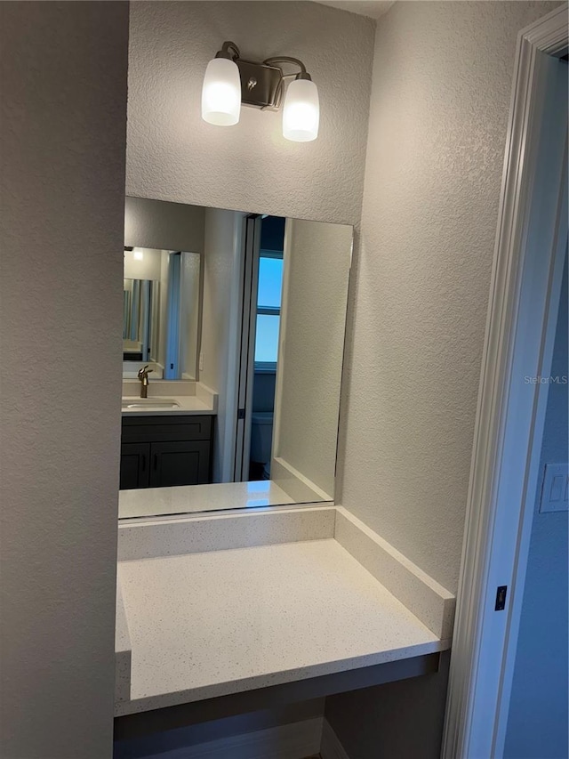 bathroom featuring a textured wall and vanity