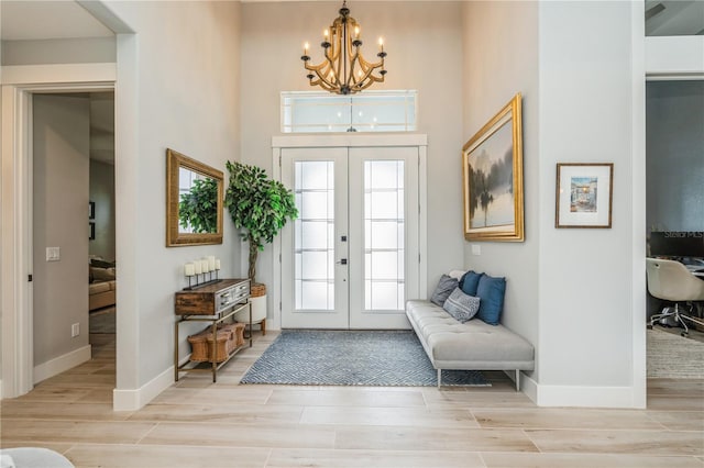 1306 Osprey Dr, Punta Gorda, FL 33950 - entrance foyer with french doors, wood finished floors, a chandelier, baseboards, and a towering ceiling