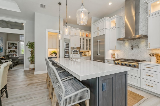 1306 Osprey Dr, Punta Gorda, FL 33950 - kitchen with wall chimney exhaust hood, stainless steel appliances, tasteful backsplash, a breakfast bar area, and recessed lighting