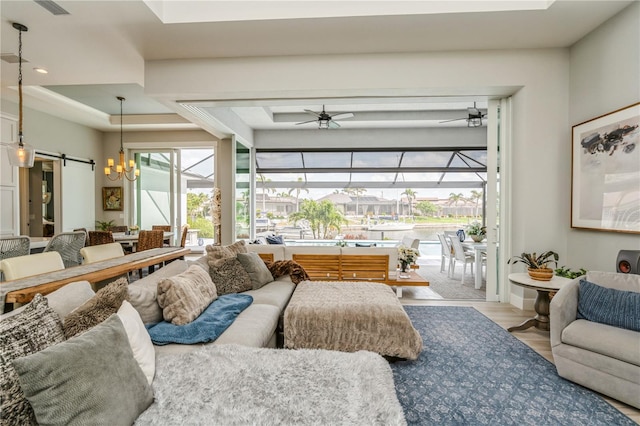 1306 Osprey Dr, Punta Gorda, FL 33950 - living area featuring a sunroom, a barn door, wood finished floors, a chandelier, and a raised ceiling