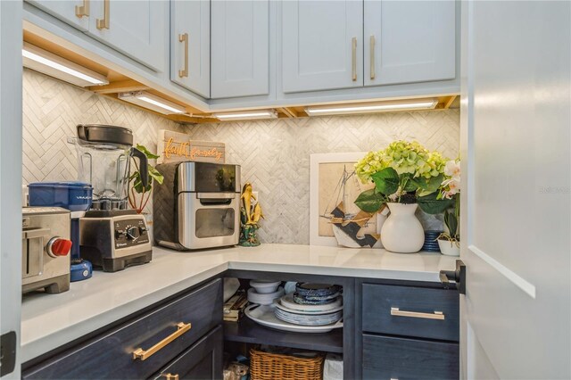 1306 Osprey Dr, Punta Gorda, FL 33950 - kitchen featuring decorative backsplash, light countertops, and blue cabinets