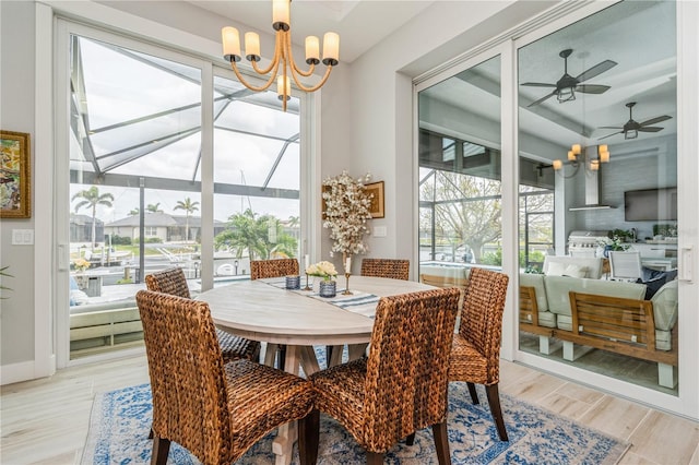 1306 Osprey Dr, Punta Gorda, FL 33950 - dining space featuring ceiling fan, light wood-style floors, a chandelier, and a sunroom