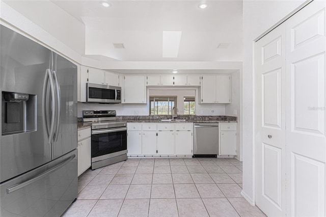 25046 Doredo Dr, Punta Gorda, FL 33955 - kitchen with appliances with stainless steel finishes, a sink, light tile patterned floors, white cabinets, and recessed lighting