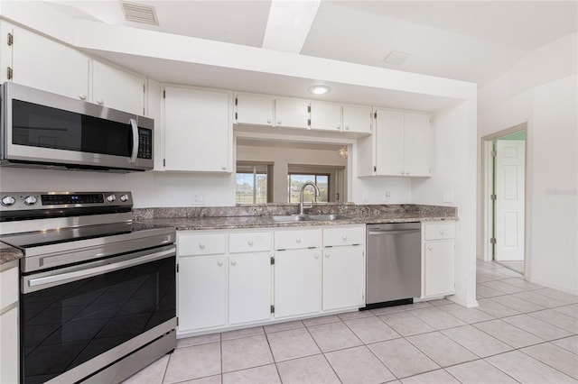 25046 Doredo Dr, Punta Gorda, FL 33955 - kitchen with stainless steel appliances, a sink, white cabinetry, and light tile patterned flooring