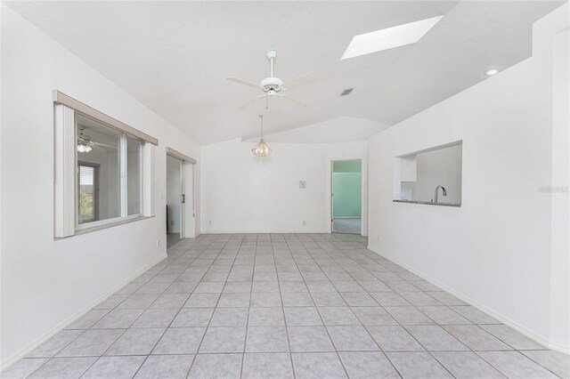 25046 Doredo Dr, Punta Gorda, FL 33955 - empty room with lofted ceiling, a ceiling fan, a skylight, light tile patterned floors, and a sink
