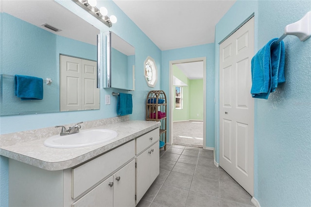 25046 Doredo Dr, Punta Gorda, FL 33955 - bathroom featuring tile patterned flooring, a textured wall, vanity, and baseboards