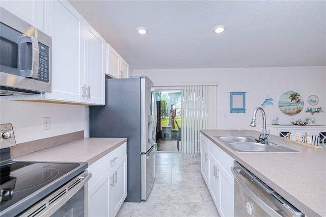25324 Aysen Dr, Punta Gorda, FL 33983 - kitchen with stainless steel appliances, a sink, white cabinetry, recessed lighting, and a textured ceiling