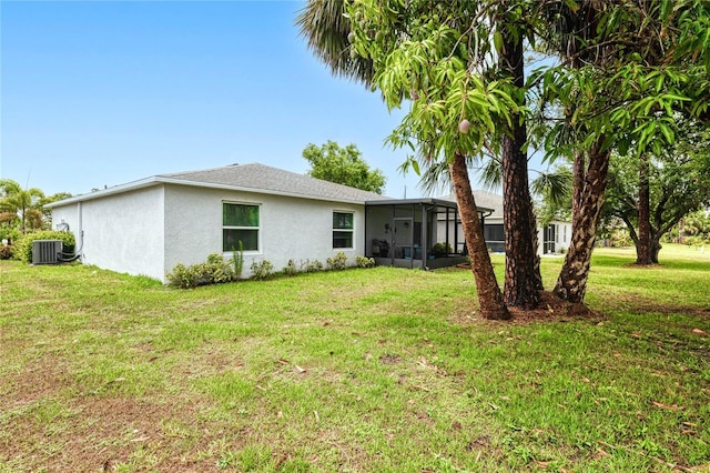 25324 Aysen Dr, Punta Gorda, FL 33983 - back of property featuring a sunroom, stucco siding, a lawn, and central air condition unit