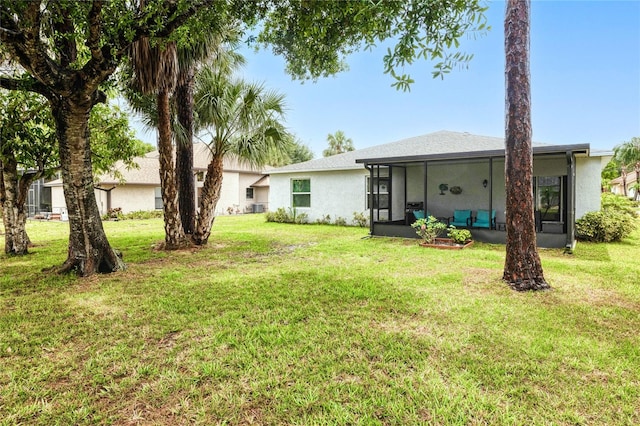 25324 Aysen Dr, Punta Gorda, FL 33983 - rear view of property with a sunroom, stucco siding, and a yard