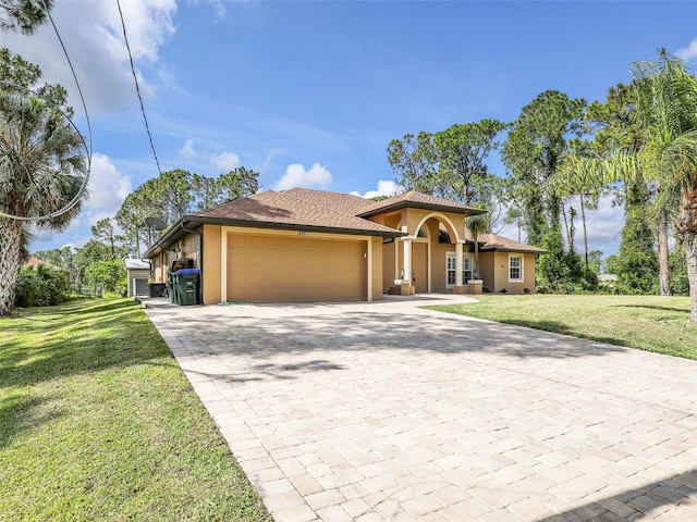 8377 Mambo Ave, North Port, FL 34291 - mediterranean / spanish-style house featuring stucco siding, a garage, decorative driveway, and a front lawn