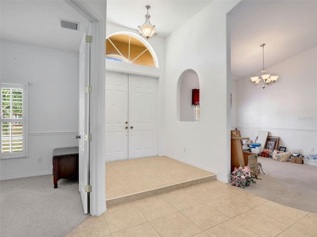 8377 Mambo Ave, North Port, FL 34291 - tiled foyer entrance featuring a chandelier, carpet flooring, high vaulted ceiling, and baseboards