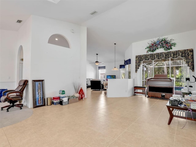 8377 Mambo Ave, North Port, FL 34291 - living area with a high ceiling, arched walkways, ceiling fan, and light tile patterned floors