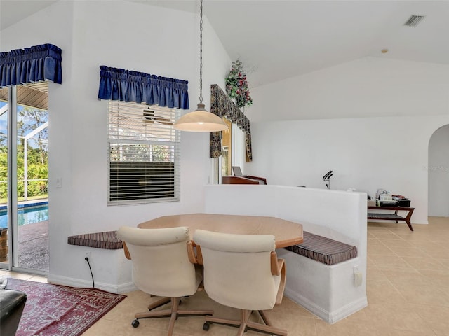 8377 Mambo Ave, North Port, FL 34291 - dining room featuring lofted ceiling, light tile patterned floors, arched walkways, and baseboards