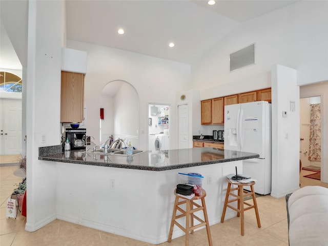 8377 Mambo Ave, North Port, FL 34291 - kitchen with white fridge with ice dispenser, a sink, a peninsula, washer / dryer, and high vaulted ceiling
