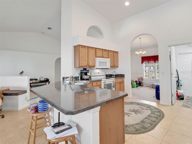 8377 Mambo Ave, North Port, FL 34291 - kitchen featuring white appliances, a sink, arched walkways, a peninsula, and light tile patterned floors