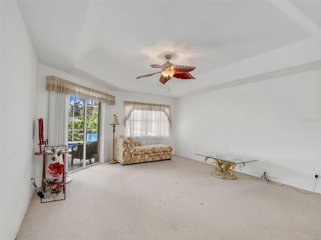 8377 Mambo Ave, North Port, FL 34291 - living area with carpet, a ceiling fan, and a tray ceiling