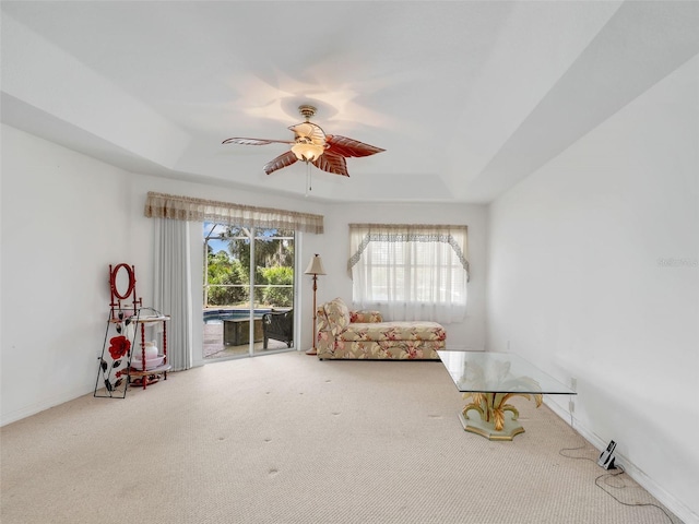8377 Mambo Ave, North Port, FL 34291 - living area featuring carpet flooring, a tray ceiling, and a ceiling fan