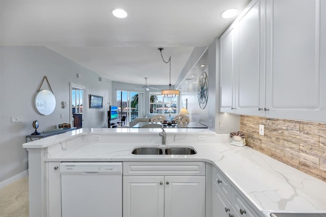 kitchen featuring dishwasher, a sink, a peninsula, decorative backsplash, and white cabinets