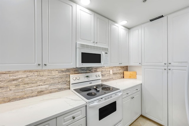 kitchen featuring white appliances, white cabinets, tasteful backsplash, and light stone countertops