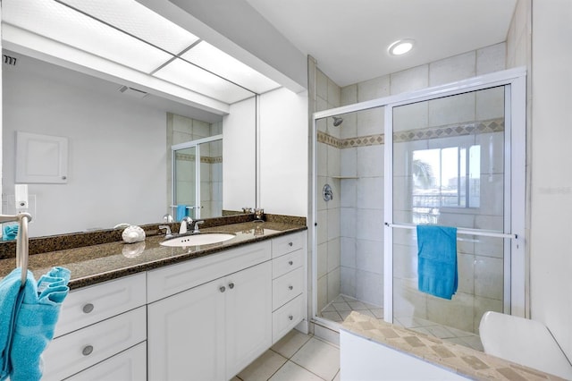 bathroom with a shower stall, tile patterned flooring, and vanity