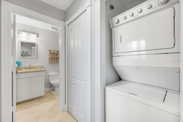 laundry area featuring estacked washer and dryer and light tile patterned floors