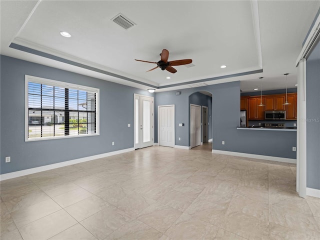 97 Pine Valley Ln, Rotonda West, FL 33947 - unfurnished living room with a raised ceiling, ceiling fan, arched walkways, baseboards, and recessed lighting