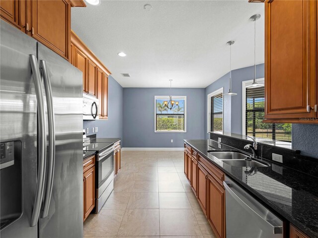 97 Pine Valley Ln, Rotonda West, FL 33947 - kitchen featuring stainless steel appliances, a sink, dark stone counters, a chandelier, and baseboards