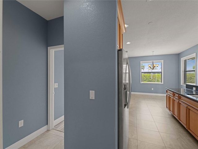 97 Pine Valley Ln, Rotonda West, FL 33947 - kitchen with stainless steel fridge with ice dispenser, a chandelier, dark countertops, baseboards, and hanging light fixtures