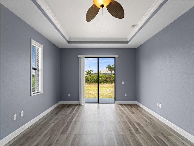 97 Pine Valley Ln, Rotonda West, FL 33947 - spare room featuring a tray ceiling, wood finished floors, a ceiling fan, baseboards, and crown molding