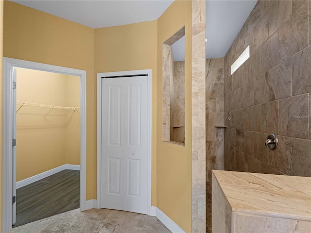 97 Pine Valley Ln, Rotonda West, FL 33947 - bathroom featuring walk in shower, baseboards, and a walk in closet