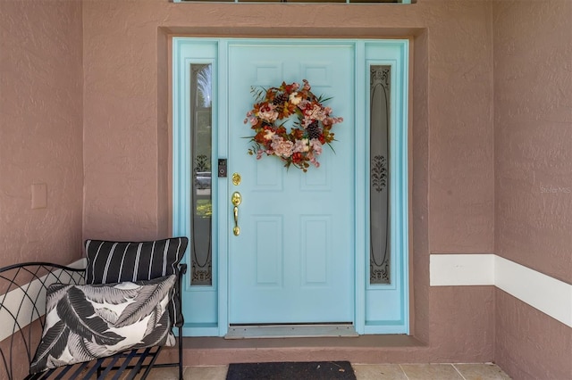 entrance to property featuring stucco siding