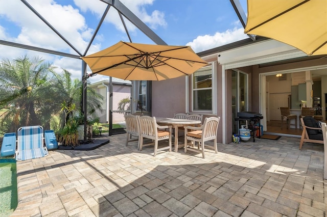 view of patio / terrace featuring a lanai, outdoor dining space, and grilling area