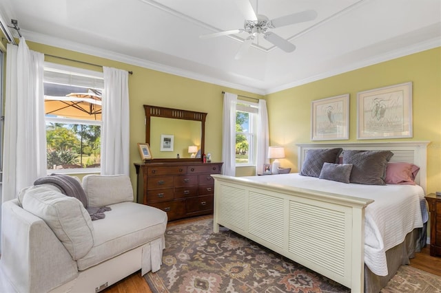 bedroom with dark wood-style flooring, crown molding, and ceiling fan