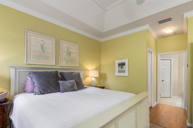 bedroom featuring crown molding, wood finished floors, and baseboards