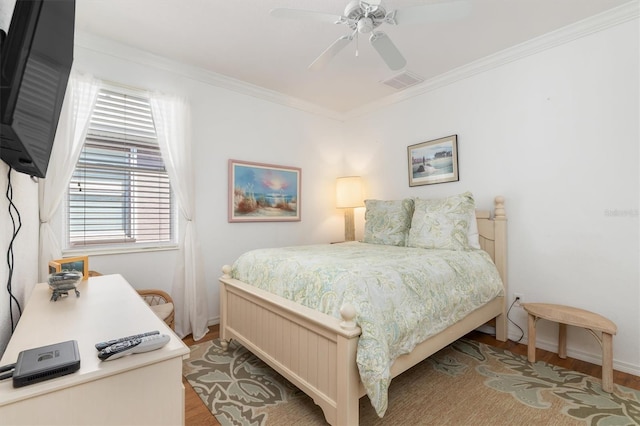bedroom featuring light wood-type flooring, baseboards, ornamental molding, and ceiling fan