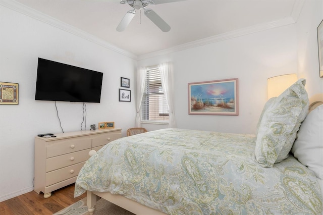 bedroom with wood finished floors, crown molding, ceiling fan, and baseboards