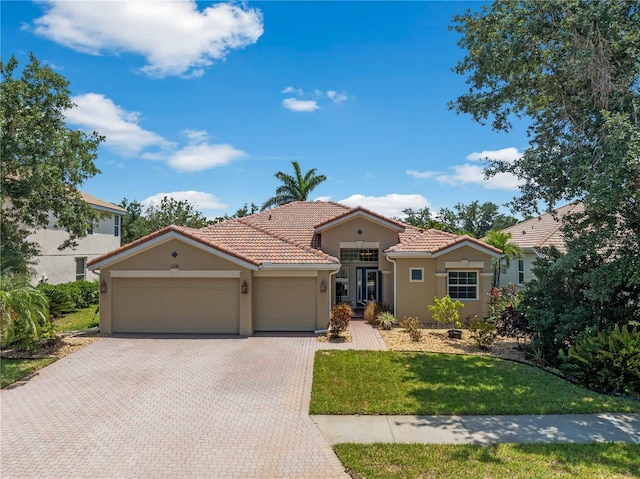 11982 Granite Woods Loop, Venice, FL 34292 - mediterranean / spanish-style home featuring an attached garage, stucco siding, driveway, and a tiled roof